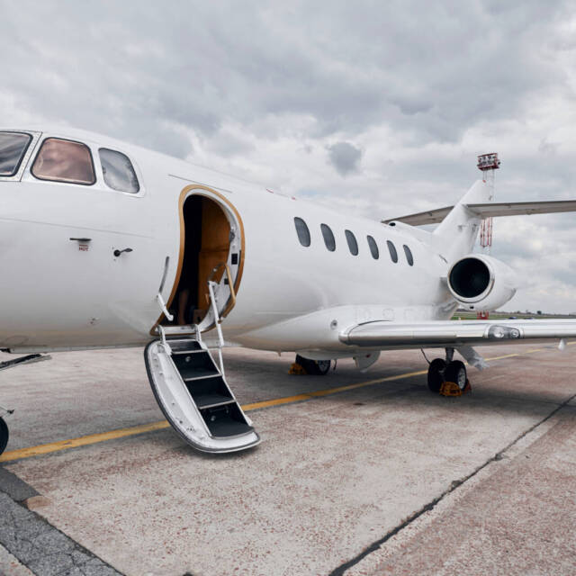 Cloudy weather. Turboprop aircraft parked on the runway at daytime.