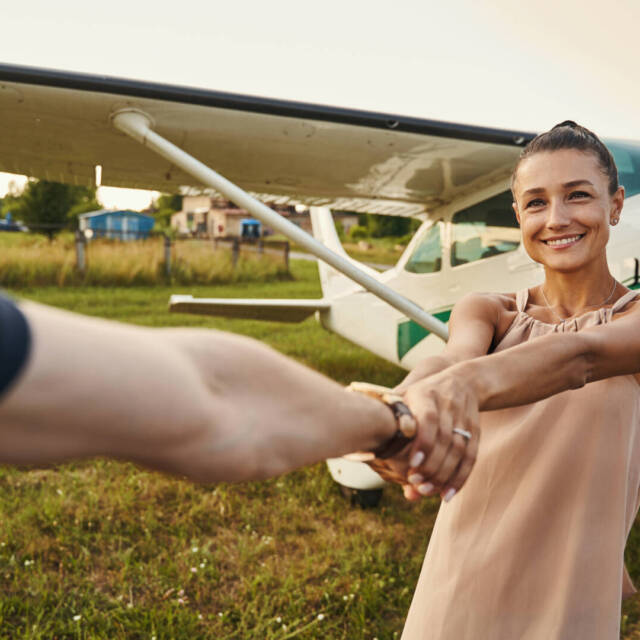 Young amazing female person expressing positivity while posing on the background of plane