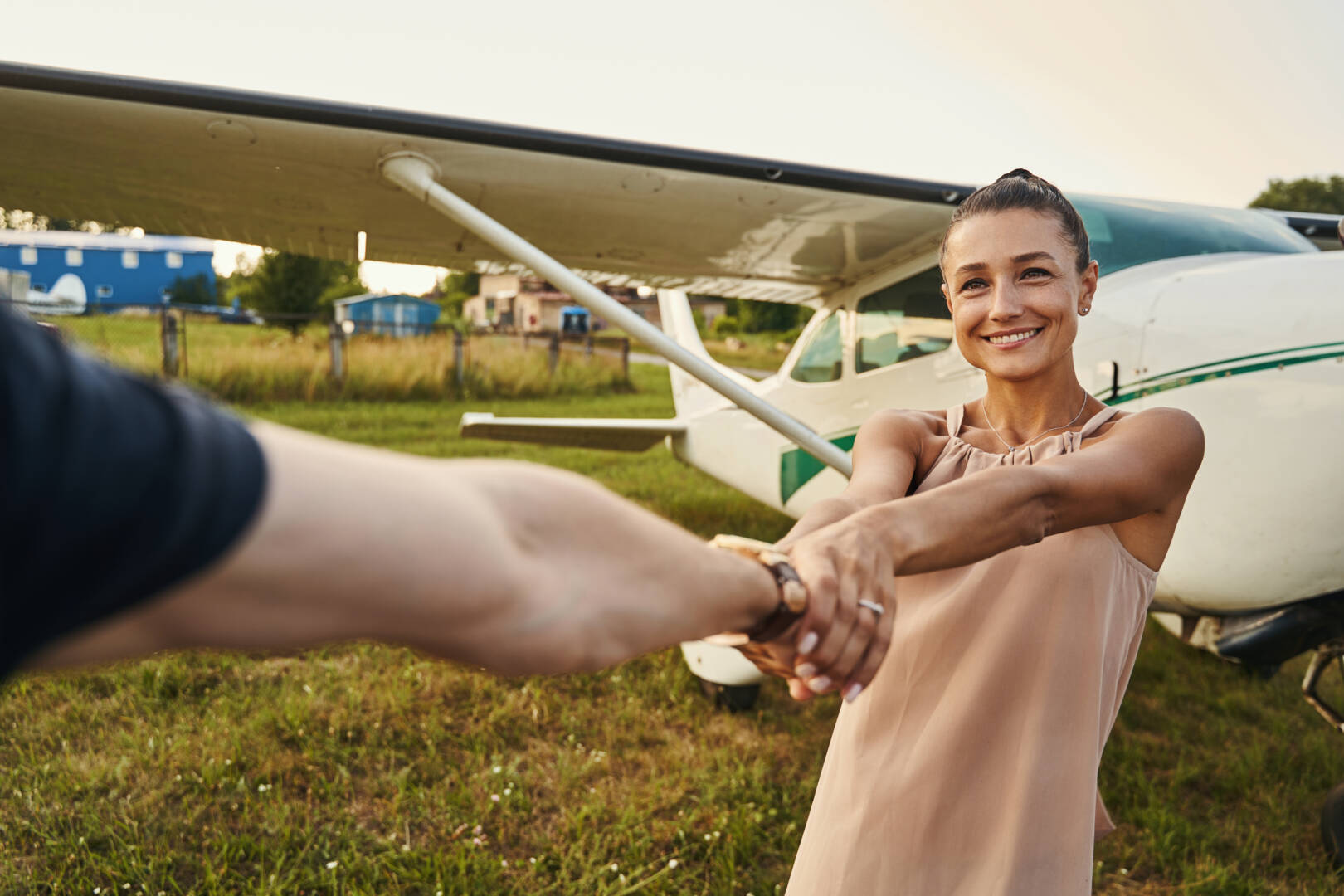 Young amazing female person expressing positivity while posing on the background of plane